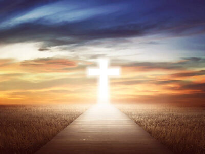 Empty path on the field going to christian cross Empty path on the field going to christian cross