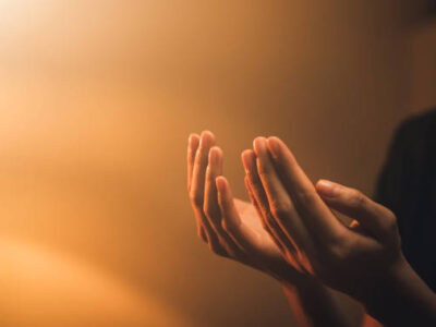Hand praying on orange light bokeh background. Hand praying on orange light bokeh background.